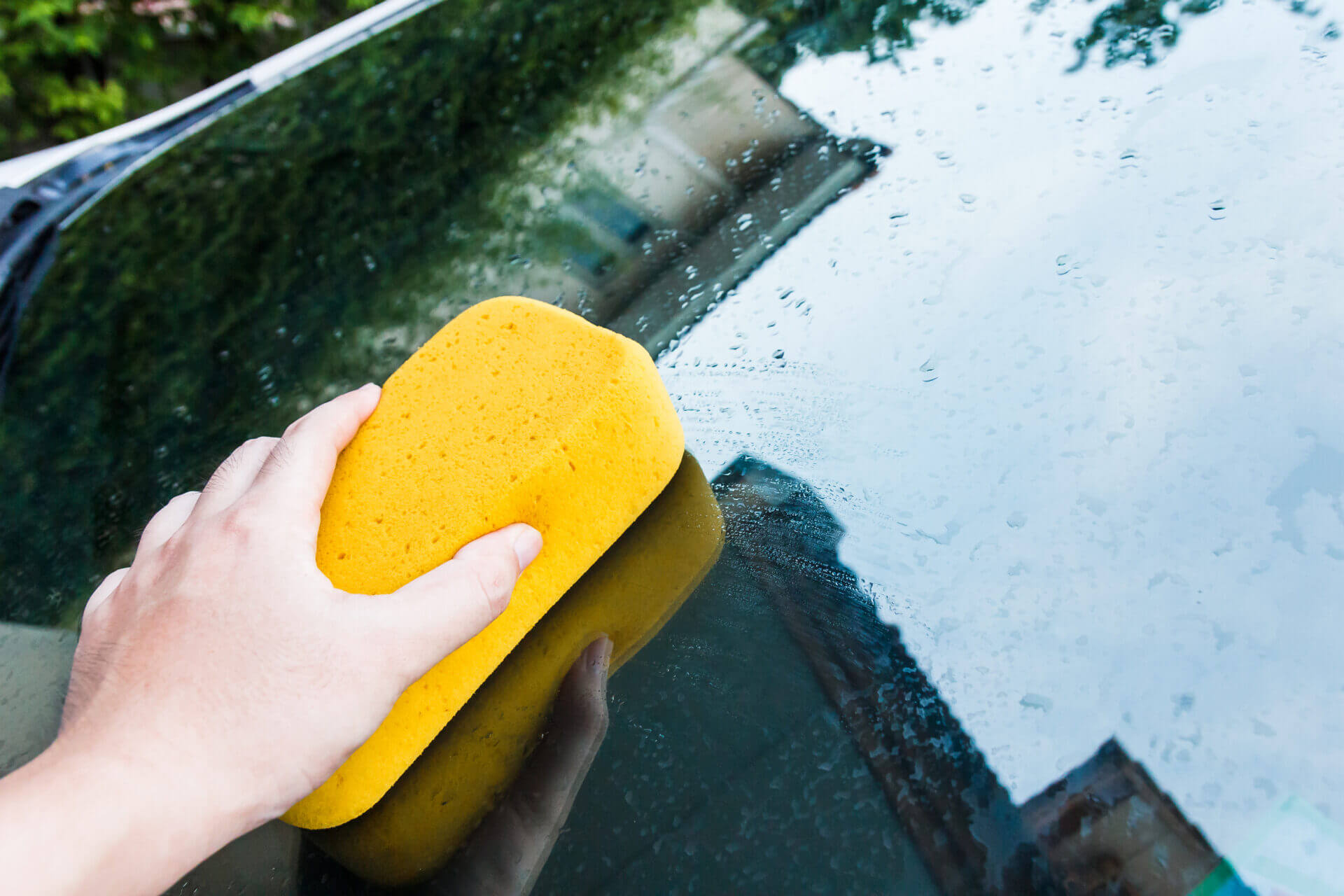 Hand Cleaning Car's Window With Sponge.